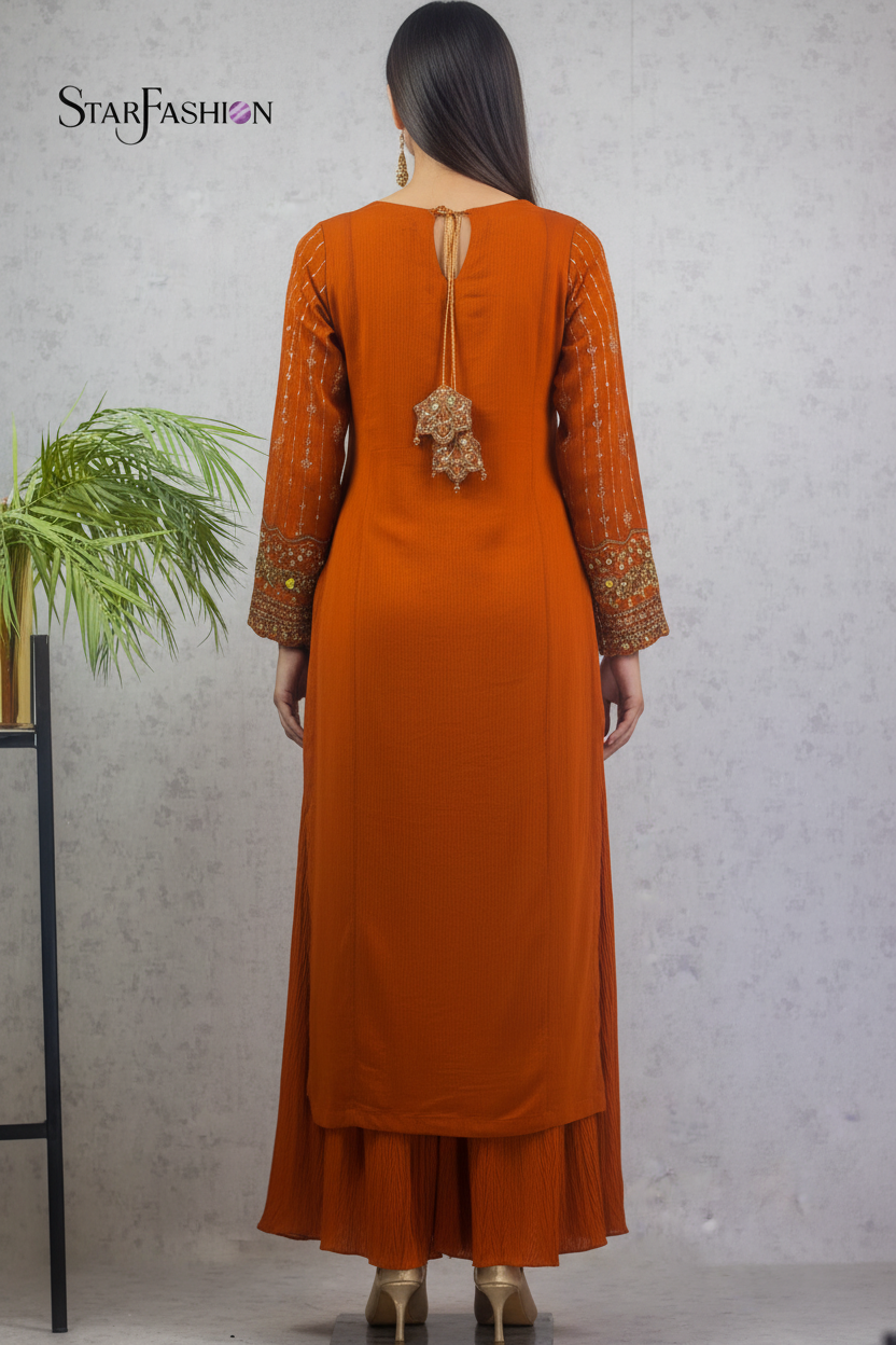 A woman is shown from the back wearing a rust-orange traditional Indian outfit with embroidered sleeves and a decorative tie at the back, standing against a textured gray wall. The brand name 'STARFASHION' is visible in the top left corner.