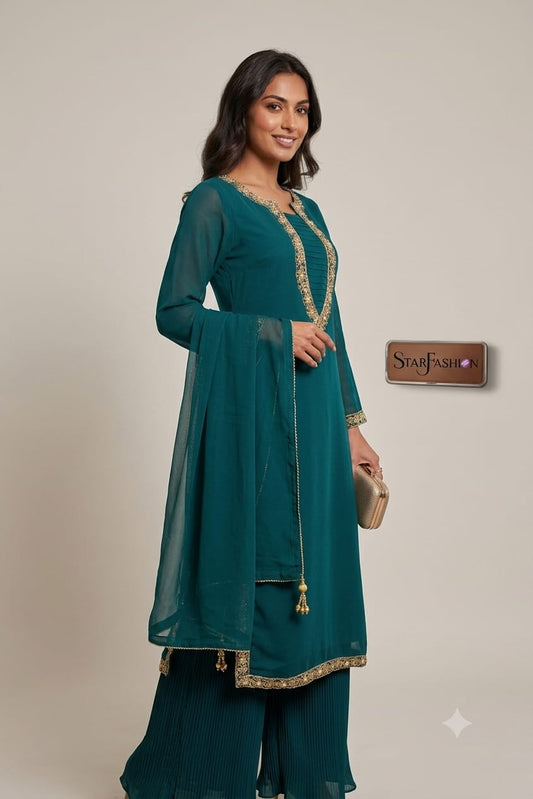 A woman modeling a teal green ethnic kurta set with gold embroidery, featuring a matching dupatta and wide-leg pants, posed against a neutral beige background.