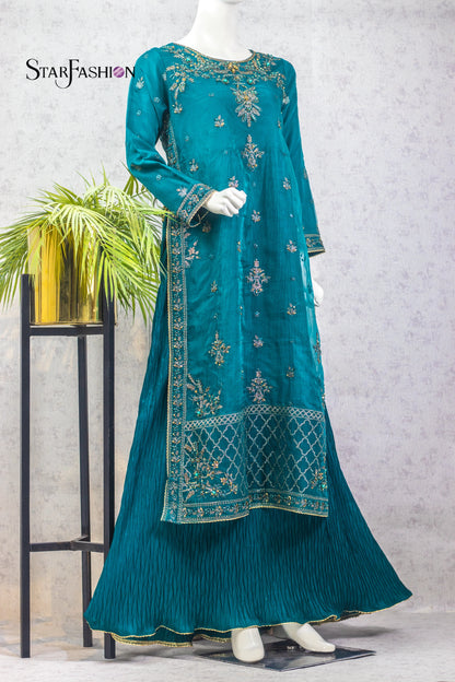 Teal embroidered dress on a mannequin with a plant and stand in the background, branded 'Star Fashion'