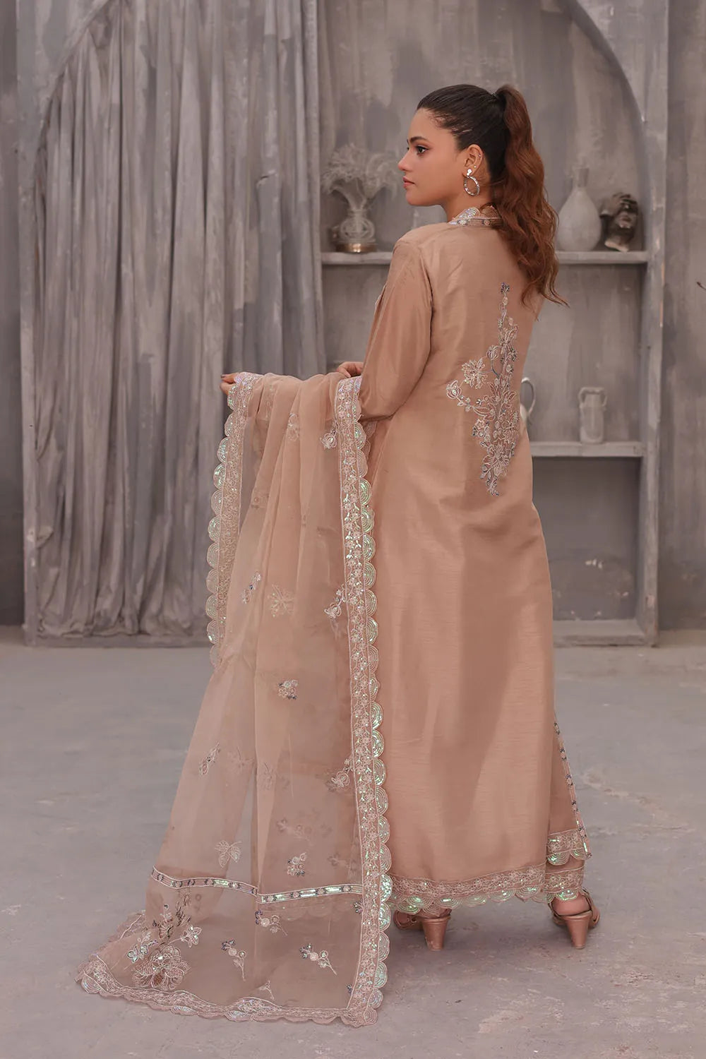 Coral pink embroidered 4-piece Pakistani suit featuring an open-style raw silk long shrug, straight-cut raw silk kurta with an embroidered neckline, raw silk palazzo with embroidered bottoms, and an embroidered organza dupatta.
