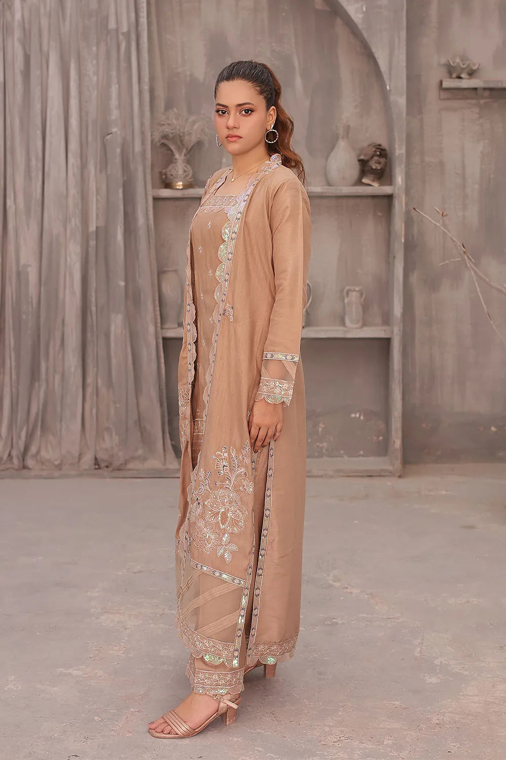 Coral pink embroidered 4-piece Pakistani suit featuring an open-style raw silk long shrug, straight-cut raw silk kurta with an embroidered neckline, raw silk palazzo with embroidered bottoms, and an embroidered organza dupatta.