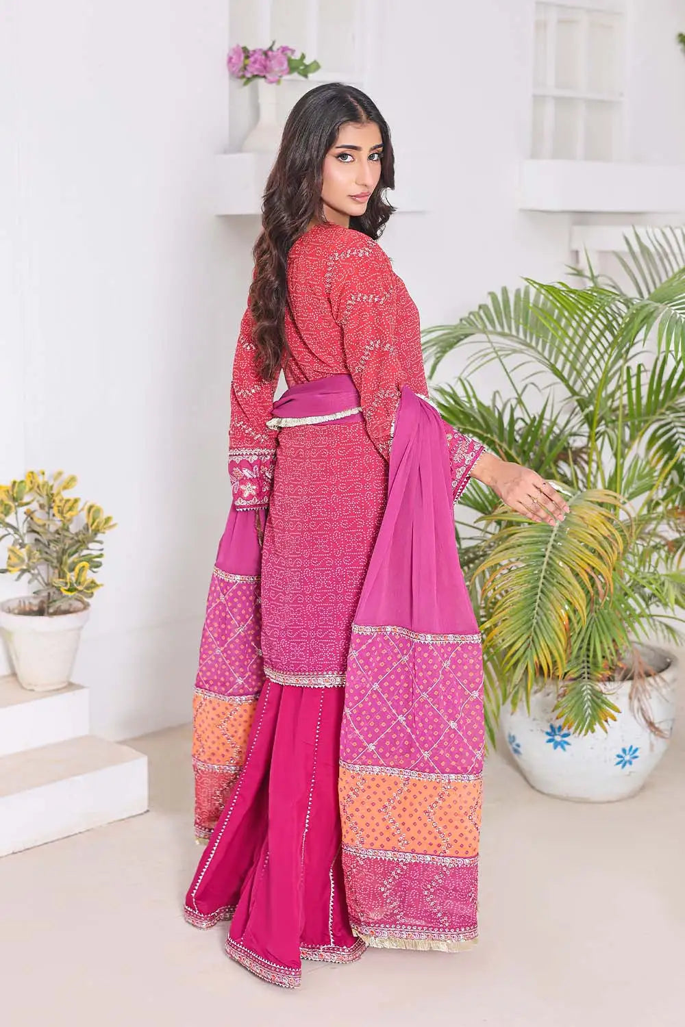 Shocking Pink three-piece women's suit featuring a Bandhani Chunri print short chiffon kurti with keyhole neckline, wide-flared crepe palazzo trousers, and chiffon dupatta with patchwork pallu.